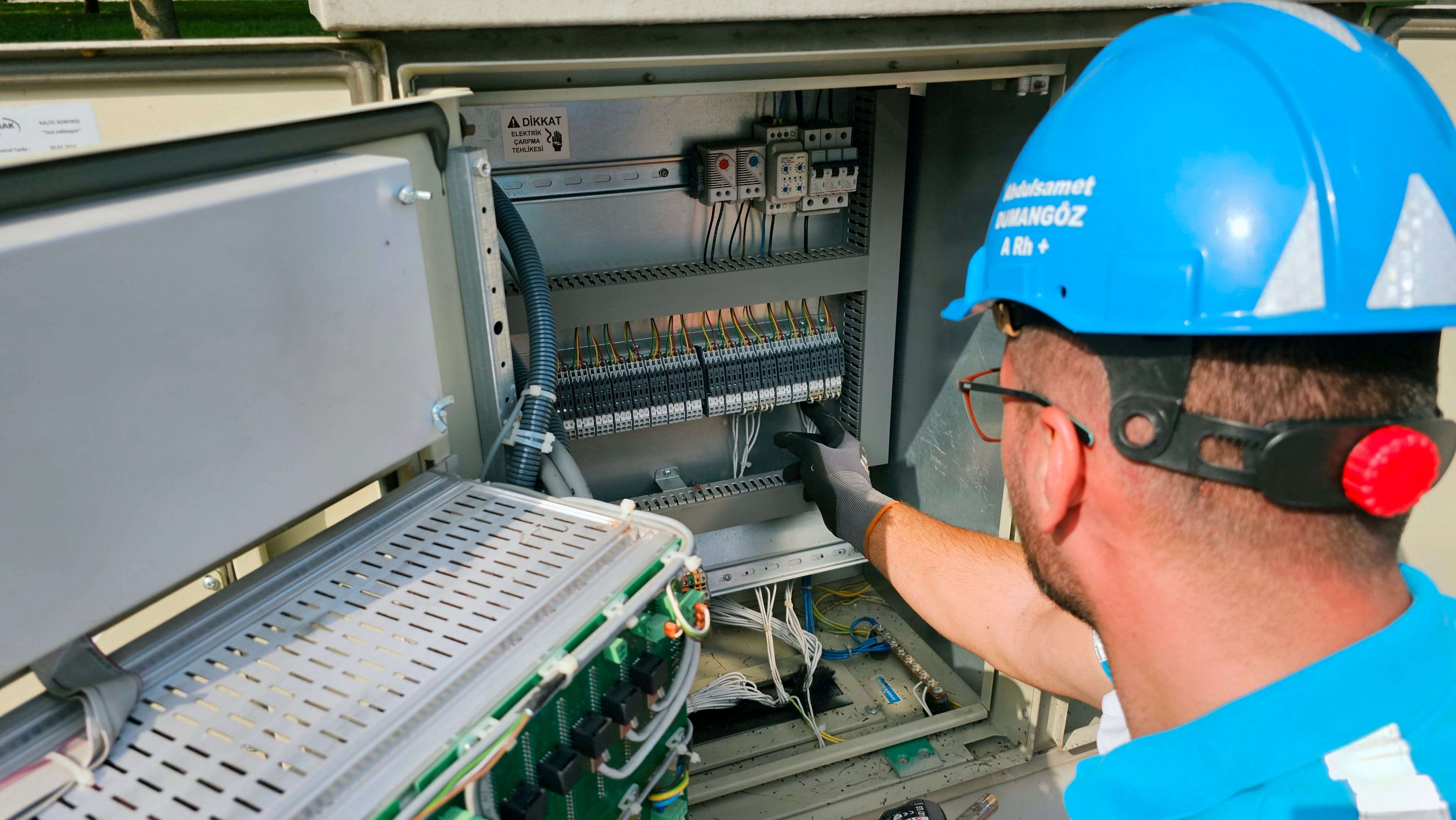 Electrician working on an outdoor fusebox